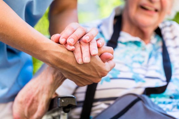 Nurse consoling senior woman holding her hand Coronavirus