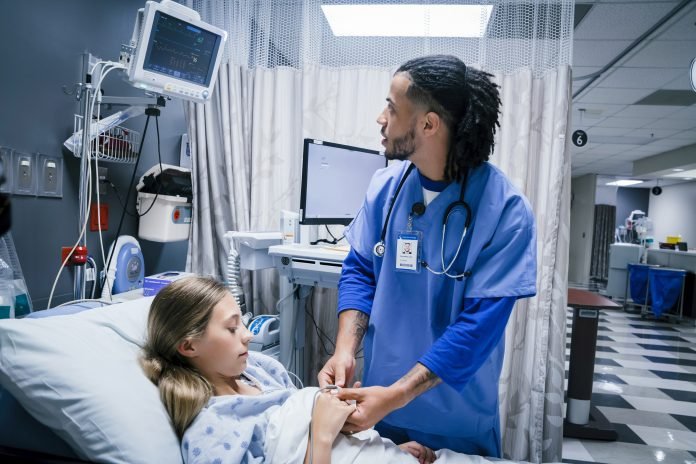Nurse placing finger monitor on patient Philips