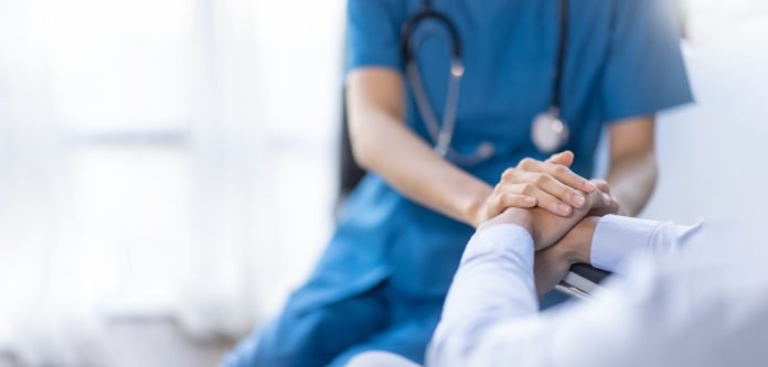 Cropped shot of a female nurse hold her senior patient's hand. Giving Support. Doctor helping old patient with Alzheimer's disease. Female carer holding hands of senior man Healthcare